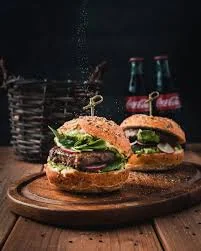 Chef's hand pressing a fresh burger patty, demonstrating the handcrafted quality of Patty Forge